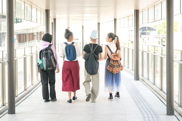 Groupe d'amis étudiants multiraciaux marchant ensemble dans le hall