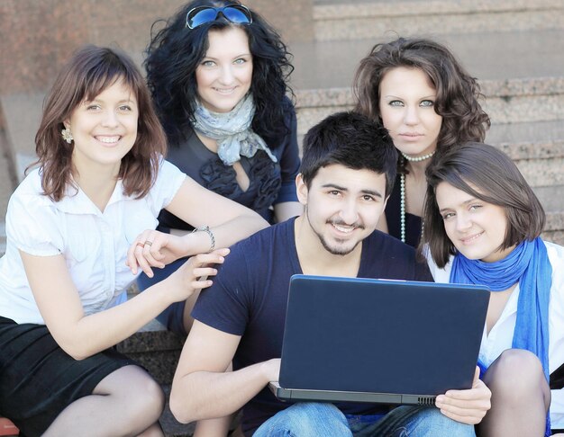 Groupe d'amis d'étudiants avec un ordinateur portable