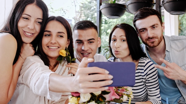 Un Groupe D'amis Fait Des Selfies Dans Un Café