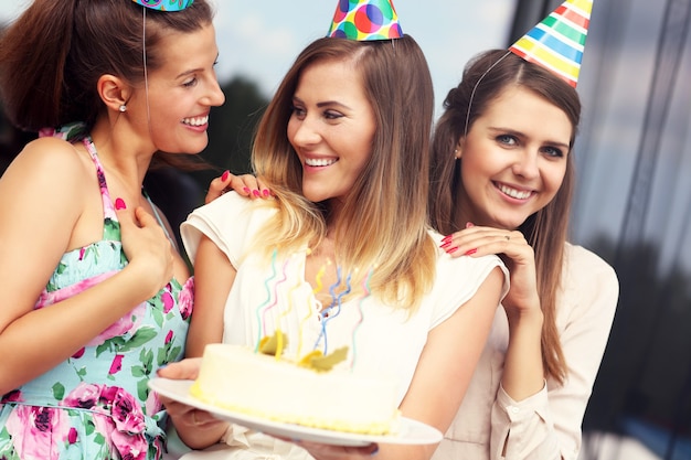 Groupe d'amis avec gâteau célébrant l'anniversaire