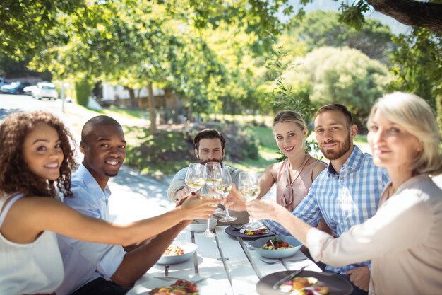 Groupe d'amis, grillage, verres de vin dans un restaurant