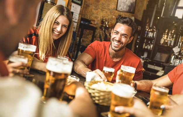 Groupe d'amis heureux buvant de la bière au restaurant-bar de la brasserie