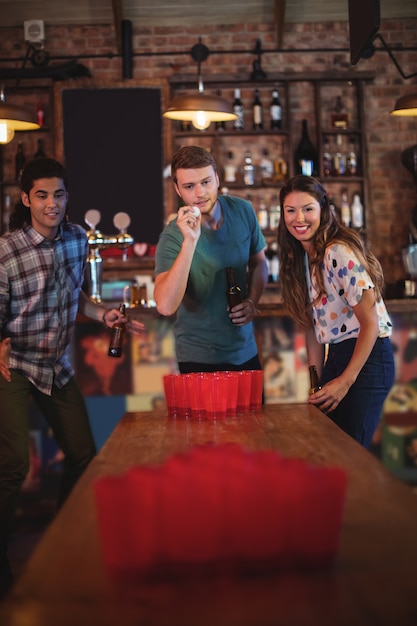 Groupe d'amis heureux jouant au jeu de bière-pong