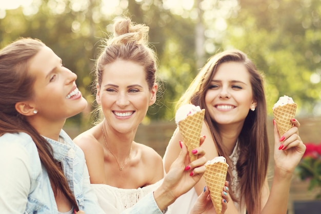 groupe d'amis heureux mangeant des glaces à l'extérieur