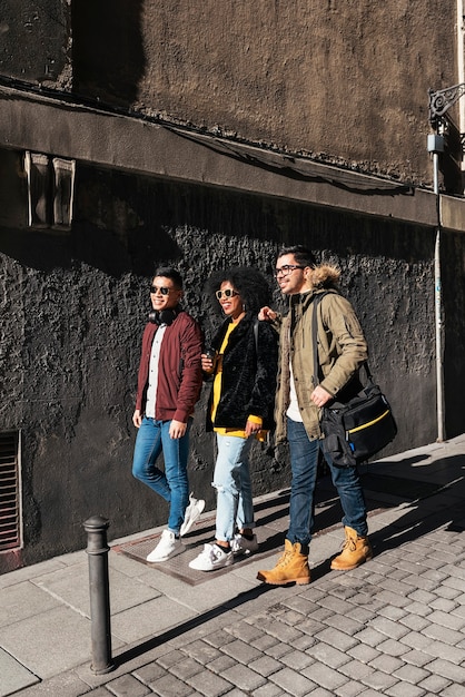 Groupe d'amis heureux marchant dans la rue. Notion d'amitié.