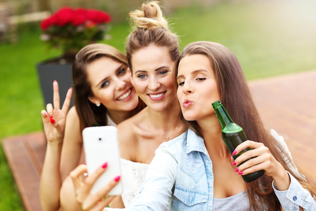 Photo groupe d'amis heureux prenant une bière à l'extérieur