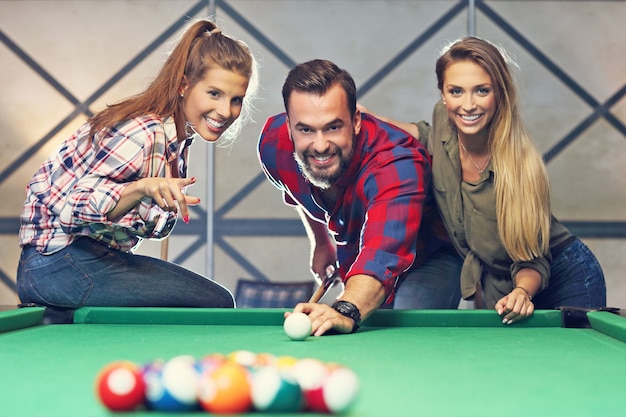 groupe d'amis jouant au billard