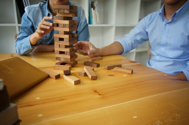 Groupe d&#39;amis jouant des blocs de jeu en bois sur la table de puzzle plié