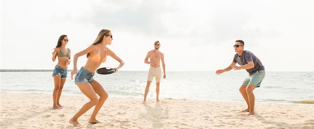 Groupe D'amis Jouant à La Plage Pendant Les Vacances D'été