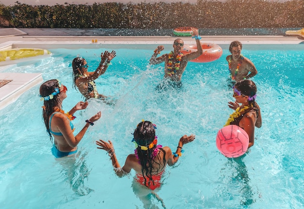 Un groupe d'amis joue ensemble dans la piscine