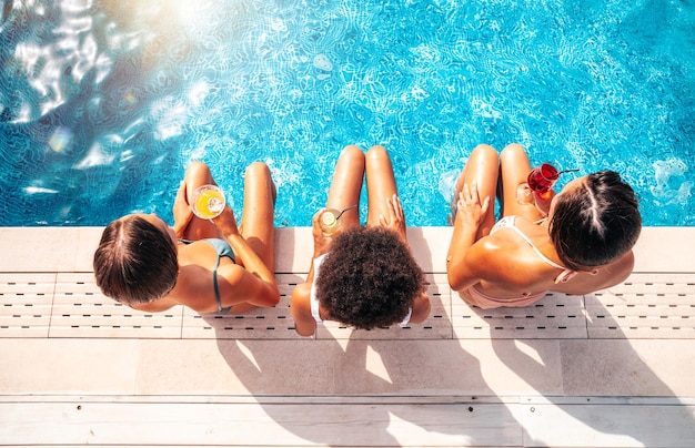 Un groupe d'amis en maillot de bain boit un cocktail sur la plage