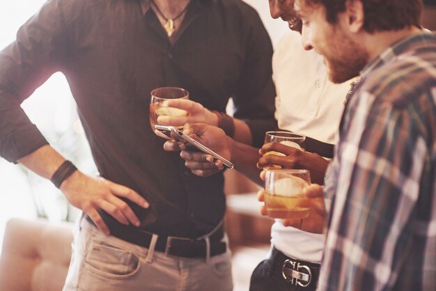 Groupe d'amis mecs avec des verres de whisky