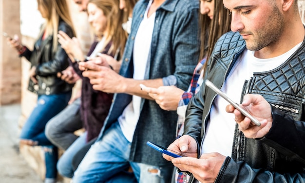 Groupe d'amis multiculturels à l'aide de smartphone à la pause du collège universitaire