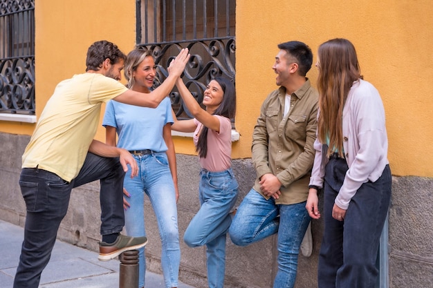 Groupe d'amis multiraciaux parlant et souriant dans le concept d'amitié de la ville avec des gars et des filles