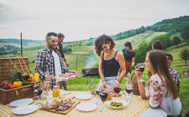 Groupe d'amis passant du temps à faire un pique-nique et un barbecue