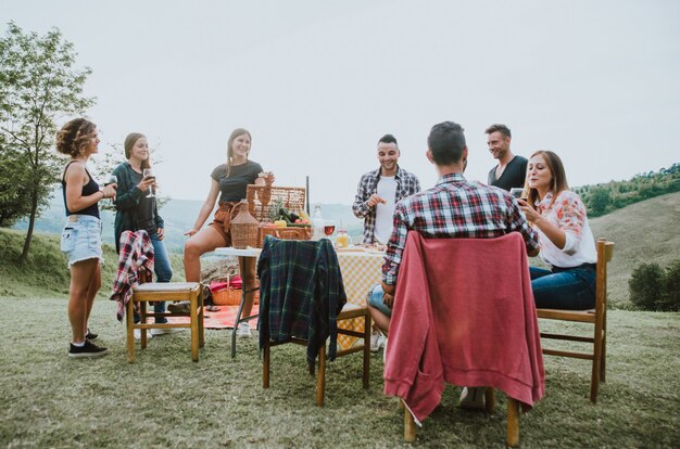 Groupe d'amis passant du temps à faire un pique-nique et un barbecue