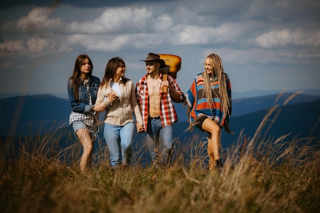 Groupe d'amis sur le pays à pied un jour d'été Jeunes hipsters randonnées dans la campagne Camping parler d'amitié