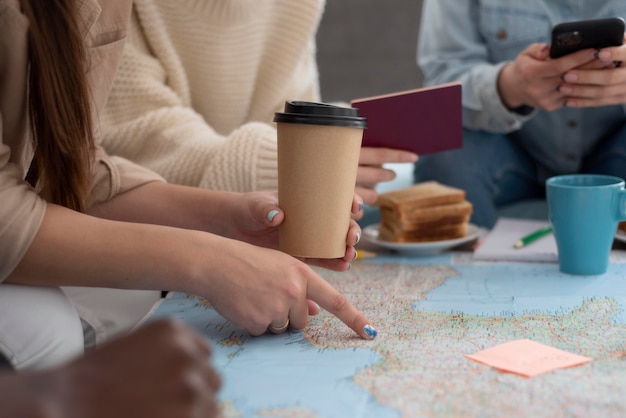 Photo groupe d'amis planifiant un voyage avec une carte