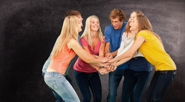 Photo groupe d'amis sur le point d'applaudir avec leurs mains empilées sur fond noir