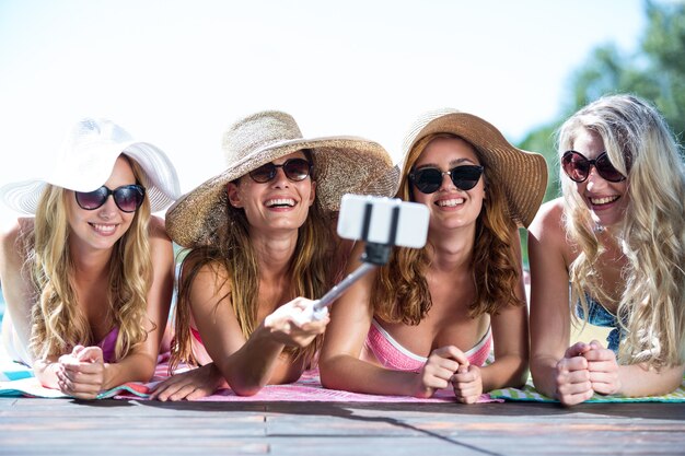 Groupe d'amis prenant selfie avec selfie stick