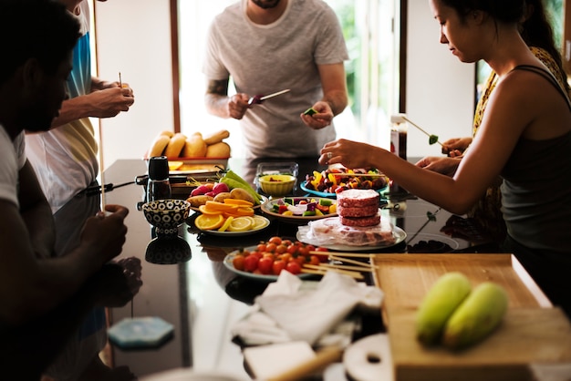 Un groupe d&#39;amis préparant un barbecue dans la cuisine ensemble