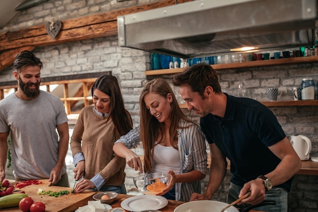 Groupe d'amis préparant le déjeuner dans la cuisine