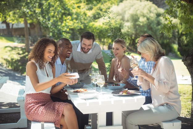 Groupe d'amis à la recherche d'image sur téléphone mobile