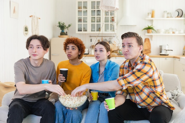 Groupe d'amis regardant un match de football à la télévision, des fans de football heureux célébrant