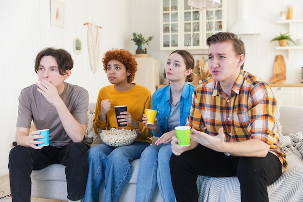 Groupe d'amis regardant un match de football à la télévision à la maison Les fans de football sont déçus