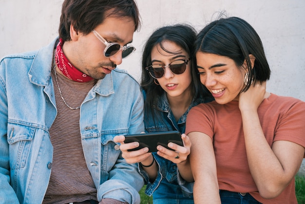 Groupe d'amis regardant quelque chose dans le smartphone.