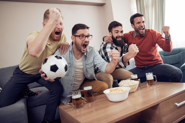 Groupe d'amis regardant le sport ensemble