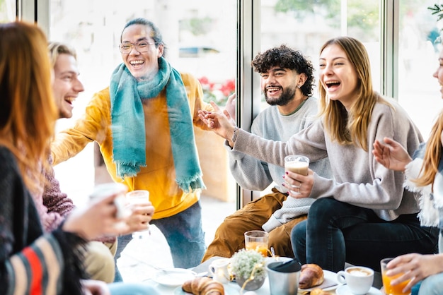 Groupe d'amis riant ensemble au café-bar