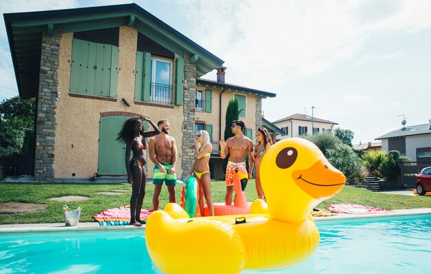 groupe d'amis s'amusant dans la piscine