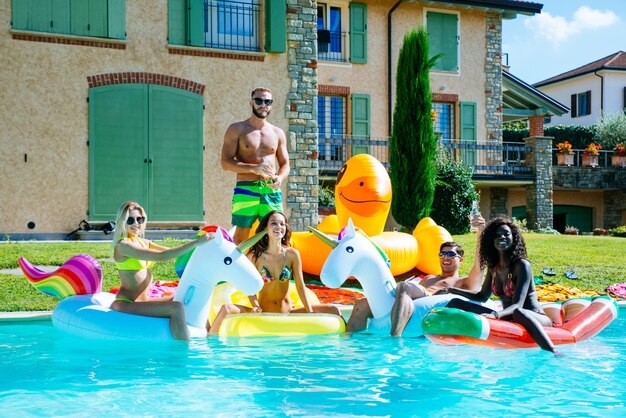 groupe d'amis s'amusant dans la piscine