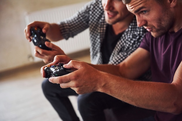 Un groupe d'amis s'amuse à jouer à un jeu de console à l'intérieur du salon.