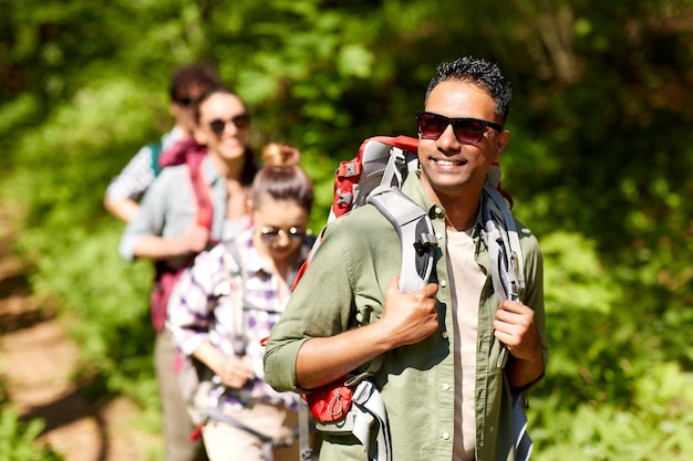 un groupe d'amis avec des sacs à dos en randonnée dans la forêt