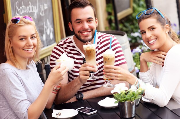 groupe d'amis se reposant dans un café en plein air