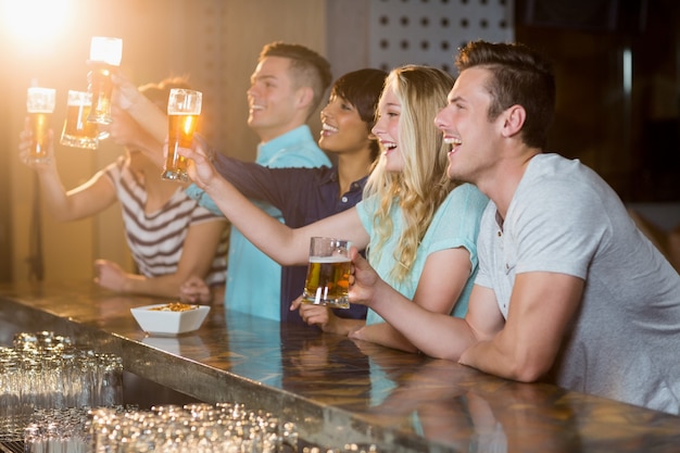 Groupe d'amis tenant un verre de bière en fête