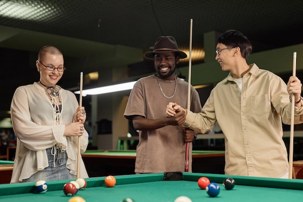 Photo un groupe d'amis en train de jouer au billard.