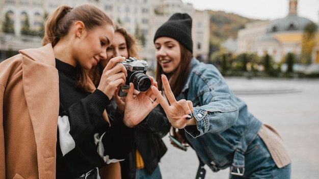 Photo groupe d'amis vérifiant la caméra professionnelle