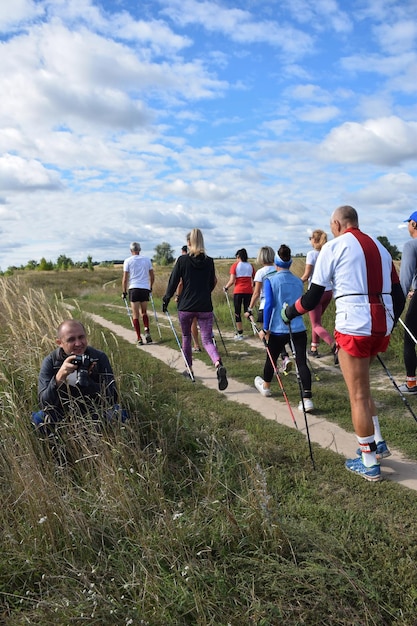 Un groupe d'athlètes de marche nordique croise un photographe lors d'une compétition