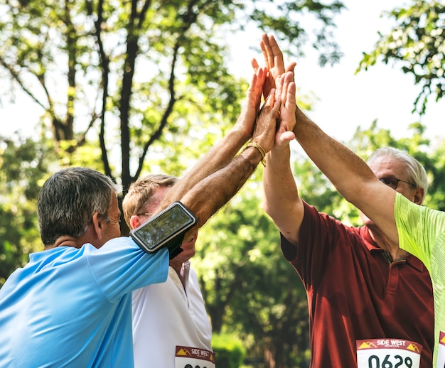 Groupe D'athlètes Seniors Donnant Un High Five