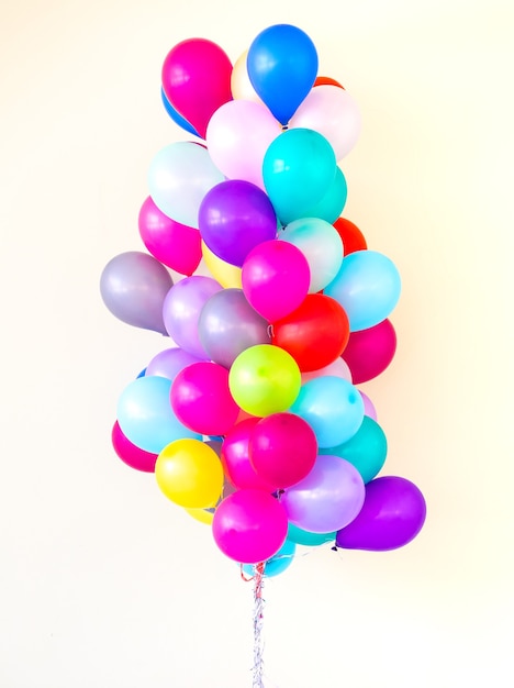 Groupe de ballons colorés sur fond de couleur pastel.