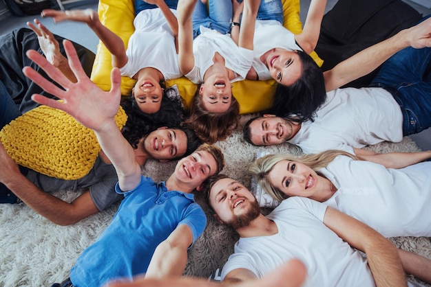 Groupe de beaux jeunes faisant des selfies allongés sur le sol meilleurs amis filles et garçons ensemble s'amusant posant concept de style de vie émotionnel