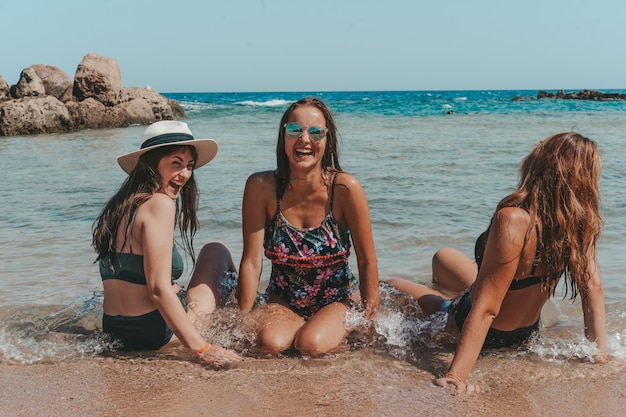 Un groupe de belles jeunes femmes se repose sur une plage.