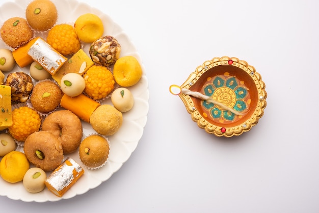 Groupe de bonbons indiens assortis ou mithai avec diya