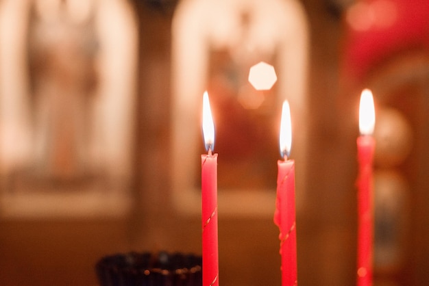 Groupe de bougies d'église brûlantes sur fond flou