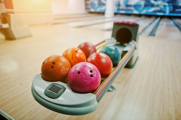 Un groupe de boules de bowling colorées à l'ascenseur du bol