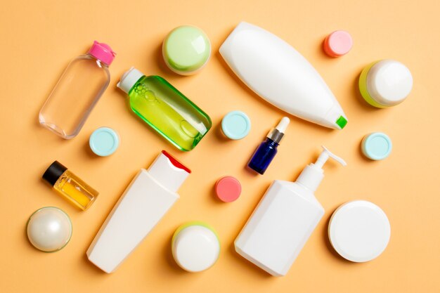 Groupe de bouteille de soins du corps en plastique Composition à plat avec des produits cosmétiques sur un espace vide de surface colorée pour votre conception