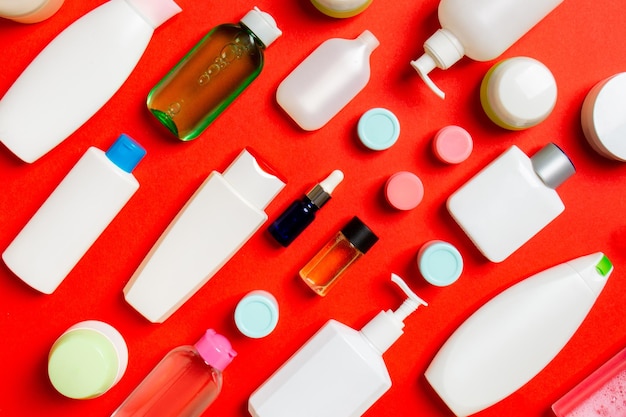 Photo groupe de bouteilles en plastique pour les soins du corps à composition plate avec des produits cosmétiques sur fond coloré